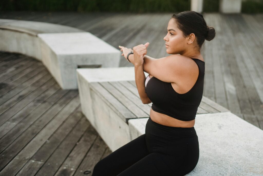 Woman stretching her arms, demonstrating tips for swimmers for dryland exercises